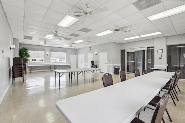 4942 Blue Heron Dr, New Port Richey, FL 34652 - dining area featuring ceiling fan, dark aggregate flooring, a paneled ceiling, and baseboards