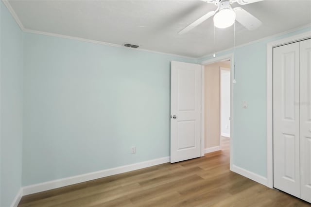 4942 Blue Heron Dr, New Port Richey, FL 34652 - unfurnished bedroom featuring wood finished floors, a closet, baseboards, crown molding, and a ceiling fan
