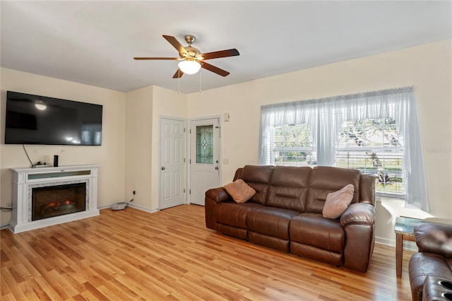 15613 Charmwood Dr, Hudson, FL 34667 - living area featuring ceiling fan, light wood-style floors, a fireplace, and baseboards