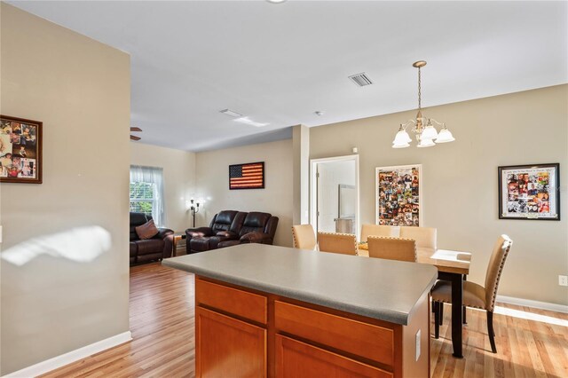 15613 Charmwood Dr, Hudson, FL 34667 - kitchen with light wood-type flooring, a chandelier, open floor plan, and baseboards