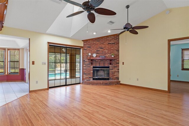 8402 Lake Hill Ct, Spring Hill, FL 34608 - unfurnished living room with light wood-style flooring, ceiling fan, baseboards, high vaulted ceiling, and a fireplace