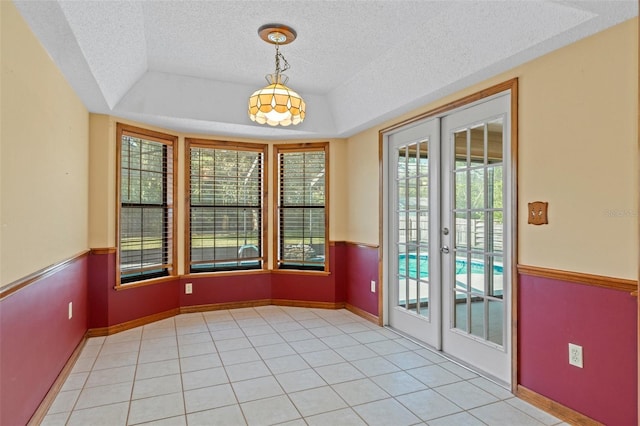 8402 Lake Hill Ct, Spring Hill, FL 34608 - spare room featuring french doors, a textured ceiling, light tile patterned floors, and a raised ceiling