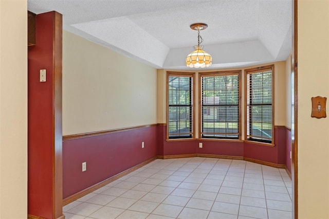 8402 Lake Hill Ct, Spring Hill, FL 34608 - empty room with a textured ceiling, a tray ceiling, baseboards, and light tile patterned floors