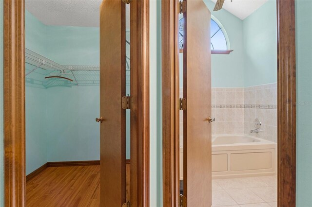 8402 Lake Hill Ct, Spring Hill, FL 34608 - full bath featuring a bath, wood finished floors, and a walk in closet
