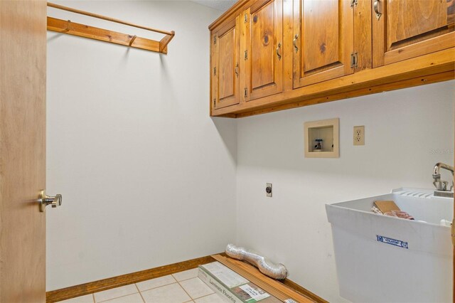 8402 Lake Hill Ct, Spring Hill, FL 34608 - laundry area with cabinet space, electric dryer hookup, washer hookup, light tile patterned floors, and baseboards