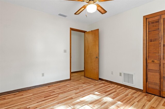 8402 Lake Hill Ct, Spring Hill, FL 34608 - unfurnished bedroom with light wood-style flooring, a closet, baseboards, and a ceiling fan