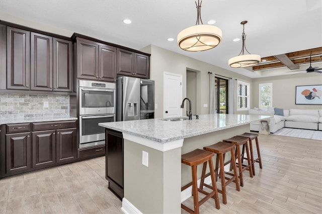 12420 Rangeland Blvd, Odessa, FL 33556 - kitchen featuring a sink, appliances with stainless steel finishes, light wood-type flooring, recessed lighting, and a kitchen breakfast bar