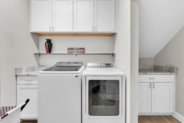 12420 Rangeland Blvd, Odessa, FL 33556 - laundry area with washing machine and clothes dryer, cabinet space, and light wood-style flooring