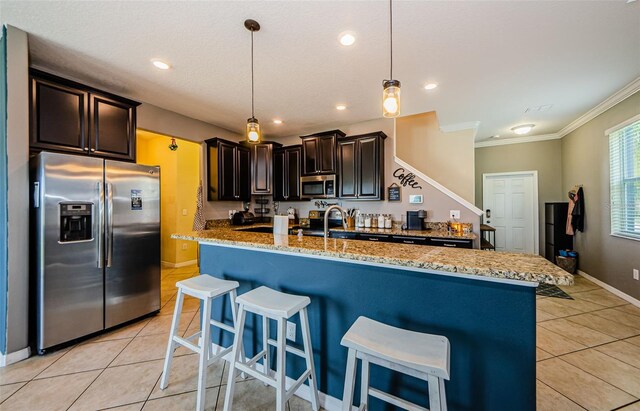 14008 Lugano Ct, Hudson, FL 34669 - kitchen with stainless steel appliances, light tile patterned flooring, light stone counters, ornamental molding, and baseboards