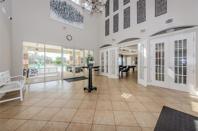 14008 Lugano Ct, Hudson, FL 34669 - workout room featuring french doors, a towering ceiling, light tile patterned floors, and baseboards