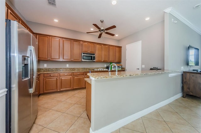 14008 Lugano Ct, Hudson, FL 34669 - kitchen with stainless steel appliances, light stone countertops, a ceiling fan, light tile patterned flooring, and brown cabinets
