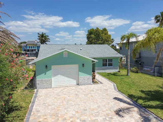 4482 Kingston Dr, Hernando Beach, FL 34607 - view of front of house with stone siding, decorative driveway, an attached garage, stucco siding, and roof with shingles