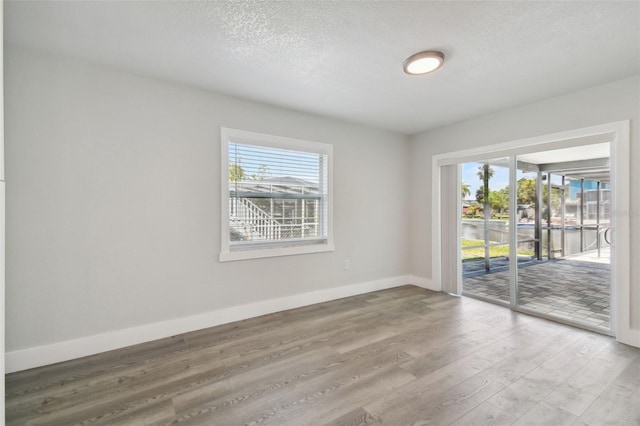 4482 Kingston Dr, Hernando Beach, FL 34607 - empty room with wood finished floors, baseboards, and a textured ceiling