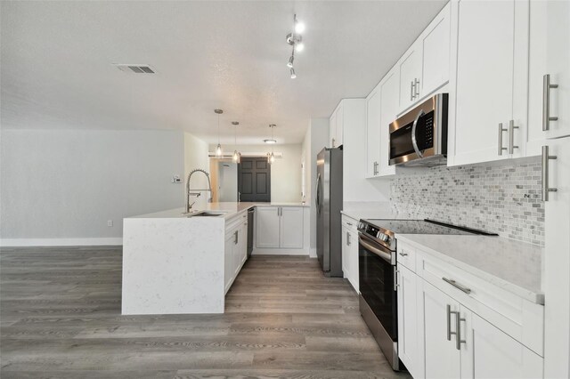 4482 Kingston Dr, Hernando Beach, FL 34607 - kitchen featuring stainless steel appliances, a sink, a kitchen island with sink, and white cabinetry