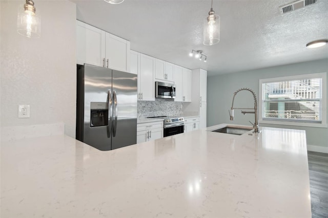 4482 Kingston Dr, Hernando Beach, FL 34607 - kitchen featuring stainless steel appliances, a sink, light stone counters, white cabinets, and tasteful backsplash