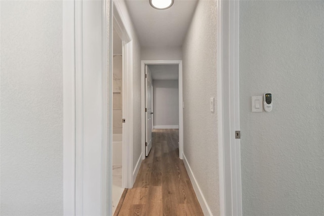 4482 Kingston Dr, Hernando Beach, FL 34607 - hall with light wood-style floors, a textured wall, and baseboards