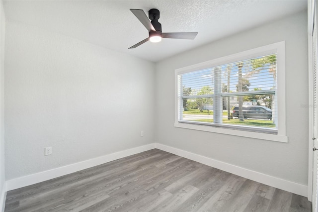 4482 Kingston Dr, Hernando Beach, FL 34607 - unfurnished room with baseboards, wood finished floors, ceiling fan, and a textured ceiling