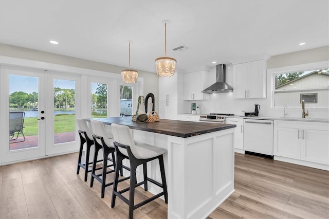 18102 Spencer Rd, Odessa, FL 33556 - kitchen with wall chimney range hood, white dishwasher, a sink, a kitchen island with sink, and high end range