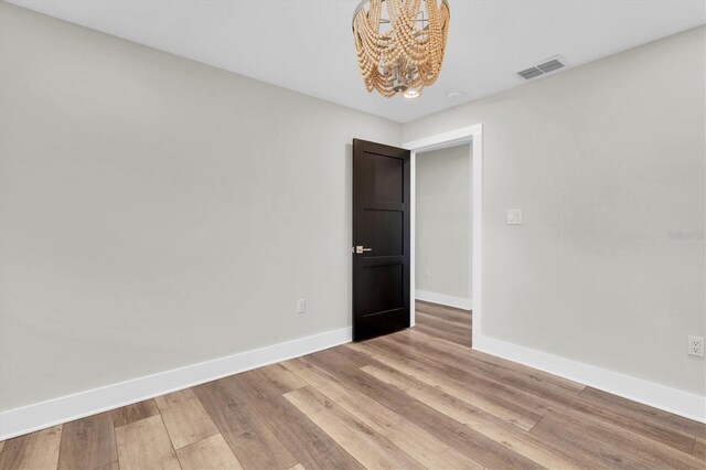 18102 Spencer Rd, Odessa, FL 33556 - unfurnished room featuring a chandelier, baseboards, and light wood-type flooring