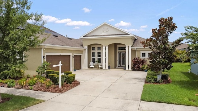 16697 Courtyard Loop, Land O Lakes, FL 34638 - view of front facade featuring an attached garage, a front yard, concrete driveway, stucco siding, and covered porch