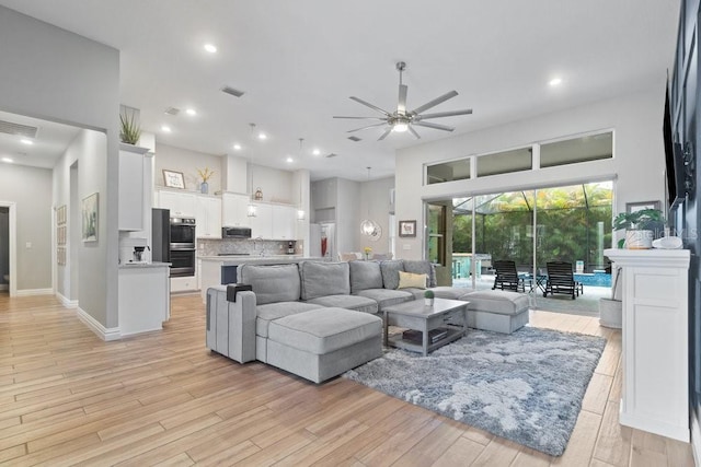 16697 Courtyard Loop, Land O Lakes, FL 34638 - living room with a ceiling fan, light wood-style floors, a high ceiling, and recessed lighting