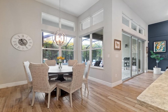 16697 Courtyard Loop, Land O Lakes, FL 34638 - dining room with a chandelier, healthy amount of natural light, light wood finished floors, and a high ceiling