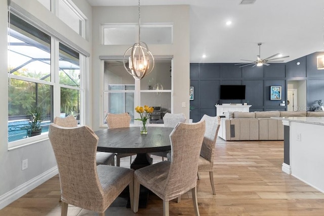 16697 Courtyard Loop, Land O Lakes, FL 34638 - dining room featuring a towering ceiling, a chandelier, light wood-type flooring, ceiling fan, and recessed lighting