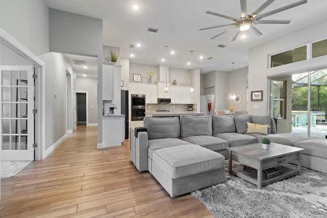 16697 Courtyard Loop, Land O Lakes, FL 34638 - living area featuring light wood-style floors, a high ceiling, a ceiling fan, and recessed lighting
