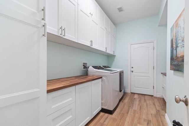 16697 Courtyard Loop, Land O Lakes, FL 34638 - laundry room featuring cabinet space, washer and clothes dryer, and light wood-style flooring