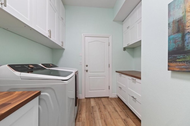 16697 Courtyard Loop, Land O Lakes, FL 34638 - washroom featuring separate washer and dryer, cabinet space, and light wood finished floors