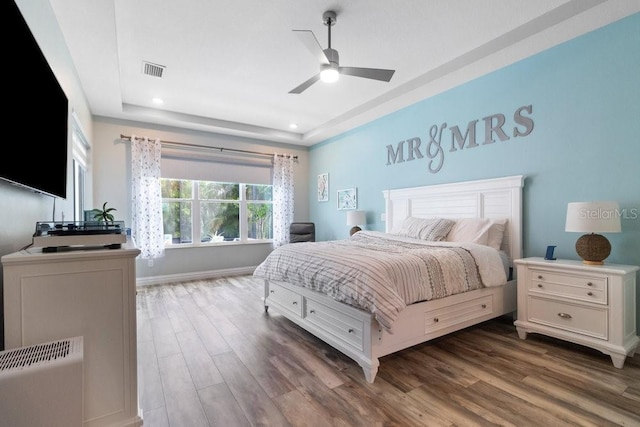 16697 Courtyard Loop, Land O Lakes, FL 34638 - bedroom with wood finished floors, a tray ceiling, recessed lighting, and a ceiling fan