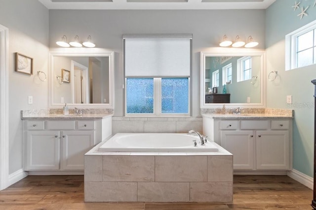 16697 Courtyard Loop, Land O Lakes, FL 34638 - full bathroom featuring a bath, two vanities, and wood finished floors