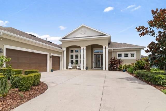 16697 Courtyard Loop, Land O Lakes, FL 34638 - view of front facade featuring stucco siding, concrete driveway, a garage, and a porch
