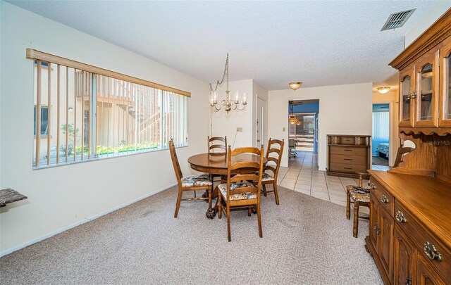 3838 Lanyard Ct Unit B, New Port Richey, FL 34652 - dining area featuring light colored carpet, a chandelier, light tile patterned floors, a textured ceiling, and baseboards