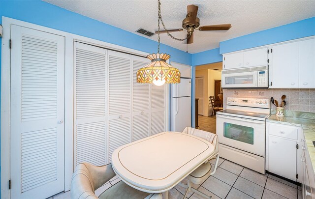 3838 Lanyard Ct Unit B, New Port Richey, FL 34652 - kitchen with white appliances, ceiling fan, white cabinetry, light countertops, and backsplash