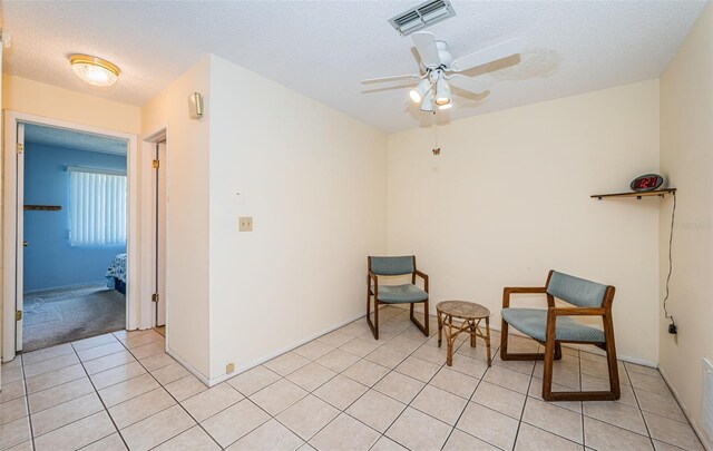 3838 Lanyard Ct Unit B, New Port Richey, FL 34652 - living area with a ceiling fan, a textured ceiling, light tile patterned flooring, and baseboards