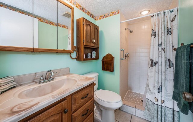 3838 Lanyard Ct Unit B, New Port Richey, FL 34652 - bathroom with toilet, vanity, a textured ceiling, tiled shower, and tile patterned floors