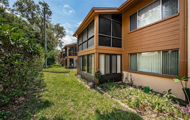 3838 Lanyard Ct Unit B, New Port Richey, FL 34652 - rear view of property featuring a sunroom, a yard, and stucco siding