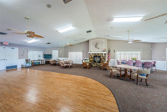3838 Lanyard Ct Unit B, New Port Richey, FL 34652 - carpeted dining room featuring ceiling fan, a textured ceiling, wainscoting, lofted ceiling, and a decorative wall