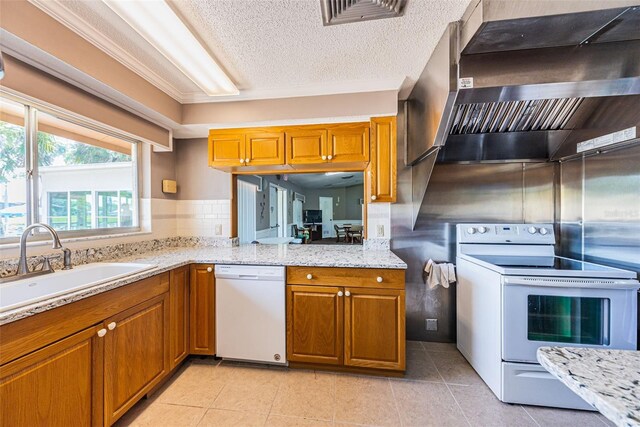 3838 Lanyard Ct Unit B, New Port Richey, FL 34652 - kitchen featuring white appliances, wall chimney exhaust hood, brown cabinets, a sink, and light stone countertops