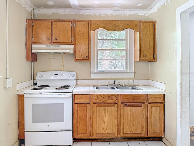 1324 SE 4th Ave, Gainesville, FL 32641 - kitchen with white electric range oven, under cabinet range hood, a sink, and brown cabinets