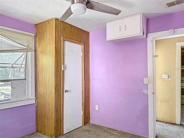 1324 SE 4th Ave, Gainesville, FL 32641 - empty room with light carpet, a ceiling fan, a textured ceiling, and wooden walls