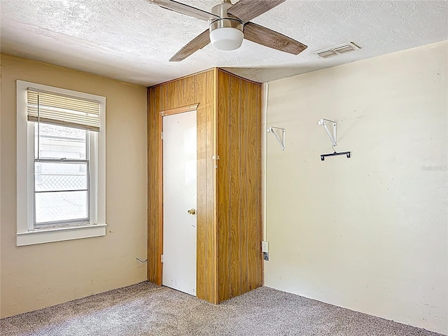 1324 SE 4th Ave, Gainesville, FL 32641 - carpeted empty room with a ceiling fan, a textured ceiling, and wooden walls