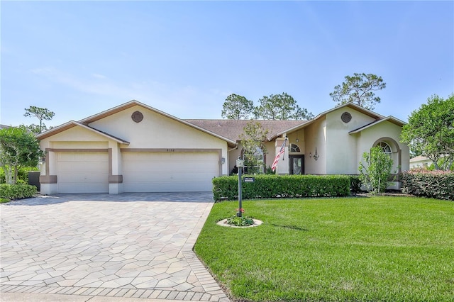 8132 Summersong Ct, Spring Hill, FL 34606 - ranch-style house with stucco siding, decorative driveway, an attached garage, and a front lawn