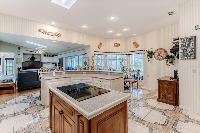 8132 Summersong Ct, Spring Hill, FL 34606 - kitchen with a kitchen island, black electric cooktop, light countertops, recessed lighting, and a ceiling fan