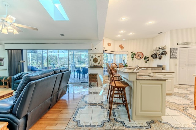 8132 Summersong Ct, Spring Hill, FL 34606 - kitchen with open floor plan, a sink, light stone counters, a kitchen bar, and ceiling fan