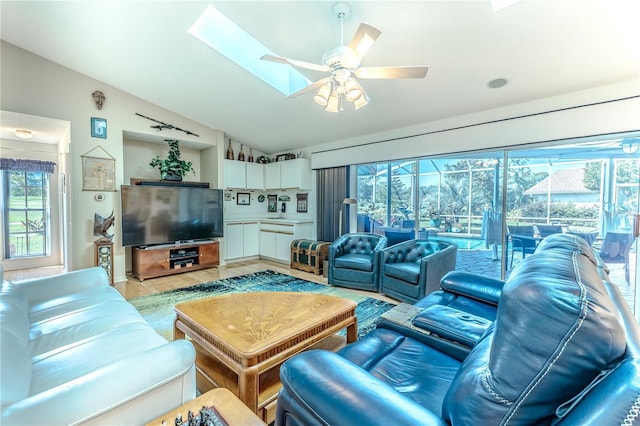8132 Summersong Ct, Spring Hill, FL 34606 - living room featuring lofted ceiling, light wood finished floors, ceiling fan, and a skylight