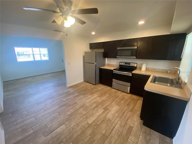 11392 Beechdale Ave, Spring Hill, FL 34608 - kitchen with appliances with stainless steel finishes, a sink, light countertops, ceiling fan, and light wood-type flooring