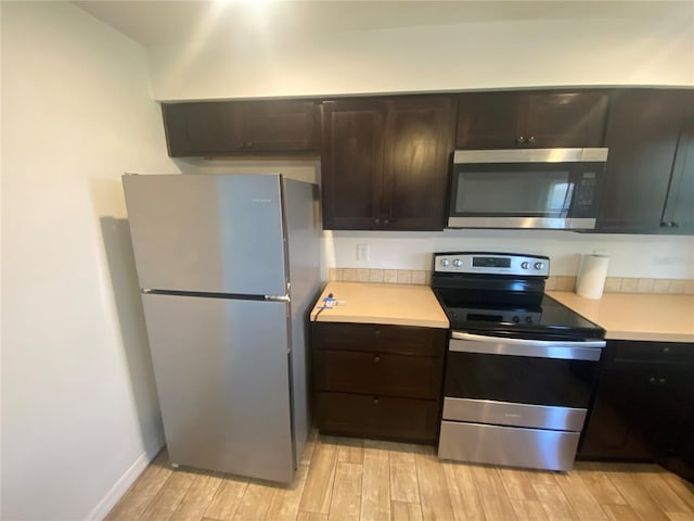 11392 Beechdale Ave, Spring Hill, FL 34608 - kitchen featuring stainless steel appliances, light countertops, light wood-style floors, and dark brown cabinets
