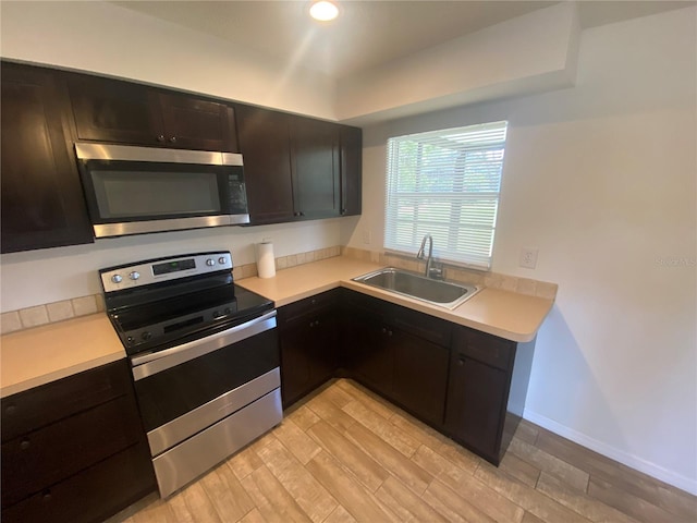 11392 Beechdale Ave, Spring Hill, FL 34608 - kitchen with appliances with stainless steel finishes, a sink, light wood finished floors, light countertops, and recessed lighting